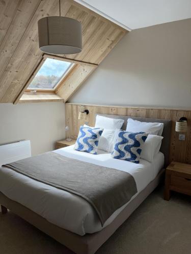 a bedroom with a large bed with a window at Hôtel Les Quatre Saisons in Dullin