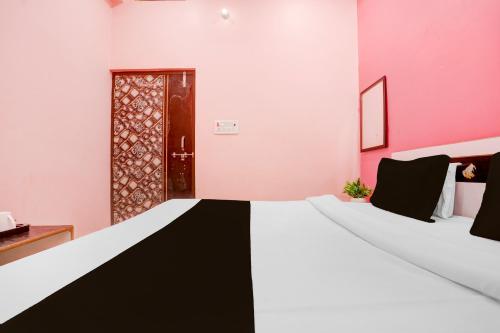 a room with a black and white bed and a door at Hotel O S G H INN in Kakarmatha