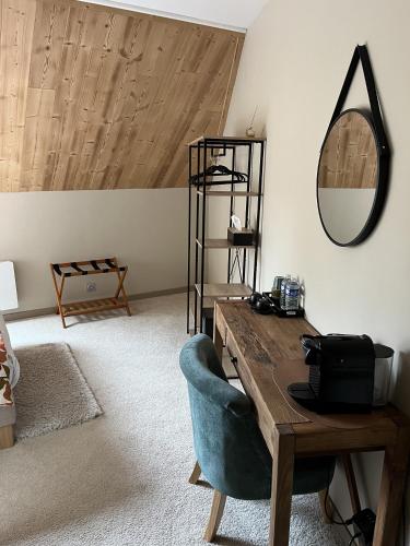 a room with a table and a mirror and a chair at Hôtel Les Quatre Saisons in Dullin