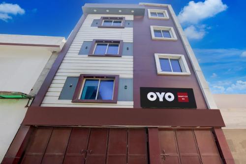 a tall purple building with a sign on it at Hotel O S G H INN in Kakarmatha