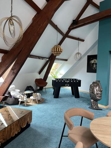 a room with a ping pong table and chairs at Hôtel Les Quatre Saisons in Dullin