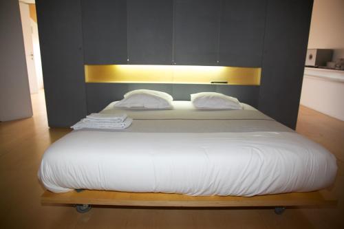 a bed with a white comforter and pillows at António Bastos 57 in Santarém