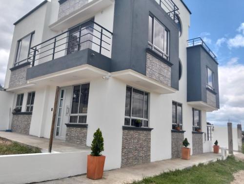 una casa bianca con accenti neri di Villa Graciela II a Paipa