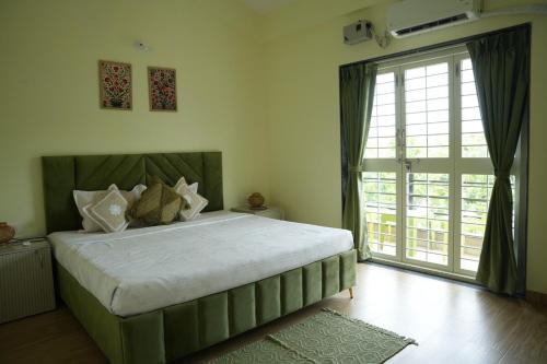 a bedroom with a large bed and a large window at Tej Villa, 3 Bhk villa at pushpam sanskruti,Karjat in Dhamni