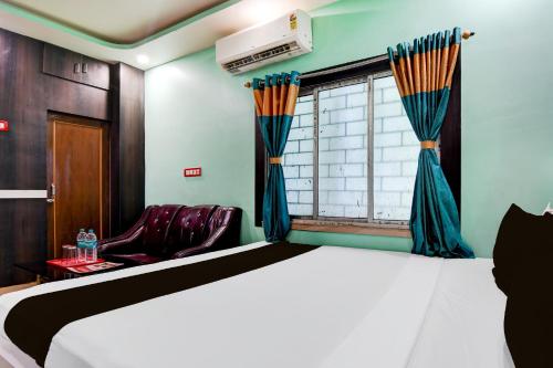 a bedroom with a bed and a window at Hotel O subharaj palace and restaurant in Kalyani