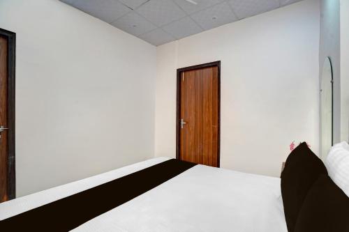 a bedroom with a bed and a wooden door at HOTEL O SMALL TOWN in New Delhi
