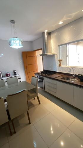 a kitchen with a table and chairs and a sink at Kingdom Of Eagles Bedroom in Londrina