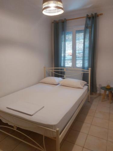 a bed in a room with a window at Samos Cozy Apartment II in Samos