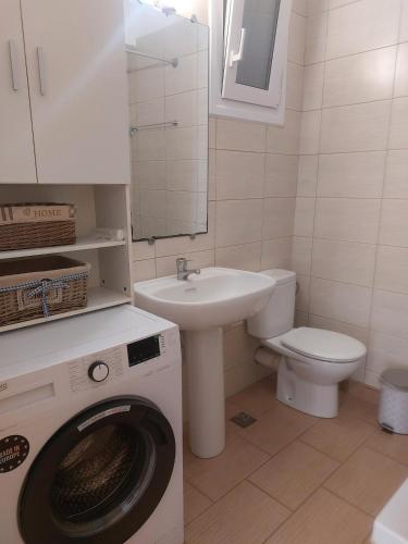 a bathroom with a washing machine and a sink at Samos Cozy Apartment II in Samos