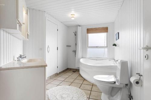 een witte badkamer met een toilet en een wastafel bij LN1972-Hjorring-Hyttefadet-13 in Hjørring