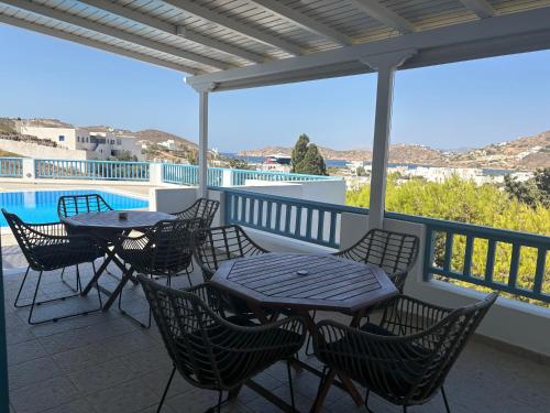 a patio with tables and chairs and a pool at Golden Sun in Ios Chora