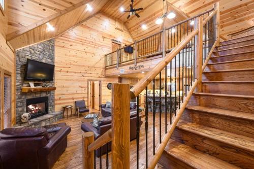 a living room with stairs and a fireplace in a log cabin at Fireside in Broken Bow