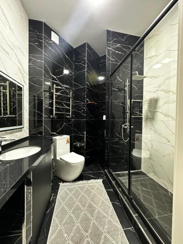 a bathroom with a toilet and a sink and a shower at BOULEVARD apartments in Tashkent