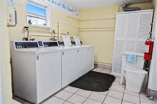 Una cocina con gabinetes blancos y una ventana. en Beachfront Comfort with Pool, Balcony & Steps to Flagler Avenue, en Chicken Island