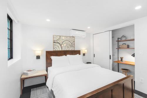 a white bedroom with a bed and a table at Sunnyside Studio on Green Lake in Seattle