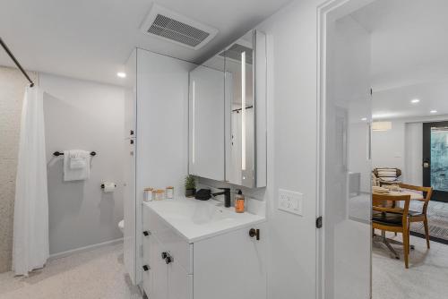 a white bathroom with a sink and a mirror at Sunnyside Studio on Green Lake in Seattle