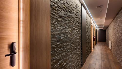 a hallway of a hotel with a stone wall at Hotel Focus in Pas de la Casa