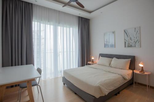 a bedroom with a bed and a desk and a window at Seaview Vacation Home, 2mins Queensbay in Bayan Lepas
