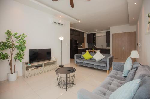 a living room with two couches and a tv at Seaview Vacation Home, 2mins Queensbay in Bayan Lepas