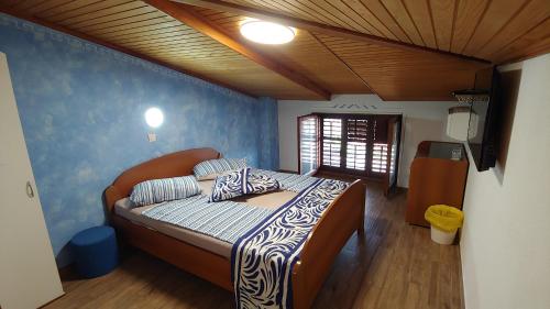 Un dormitorio con una cama con una pared azul. en Villa Senegačnik, en Portorož