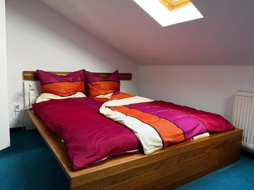 a bed with colorful blankets and pillows in a room at Wohnung in Waldnähe in Waltershausen