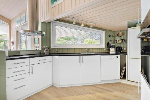 a kitchen with white cabinets and a window at LN719-Hjorring-Skagerakvej-7 in Hjørring
