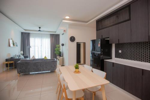 a kitchen and living room with a table and a couch at Seaview Vacation Home, 2mins Queensbay in Bayan Lepas