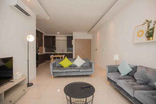 a living room with two couches and a table at Seaview Vacation Home, 2mins Queensbay in Bayan Lepas