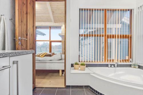 a bathroom with a bath tub and a bedroom at LN1900-Hirtshals-Kragekaeret-11 in Hirtshals