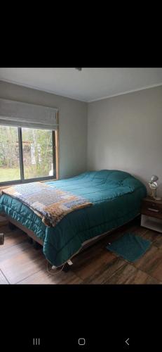 a bed in a bedroom with a window at Cabaña en el claro in Pucón