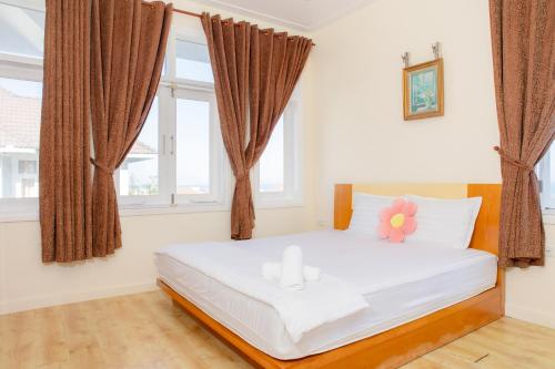 a bedroom with a white bed with a flower on it at Sealink Mũi Né Villa 5 Phòng - Biệt Thự Nguyễn Dung in Ấp Phú Tịnh (2)