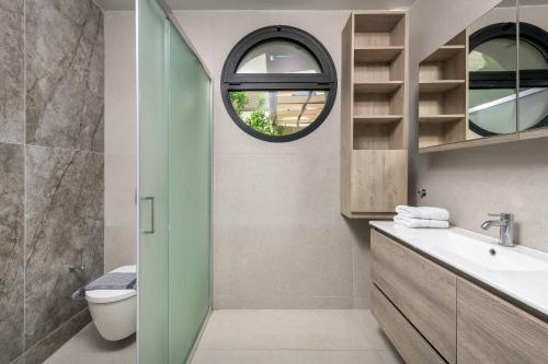 a bathroom with a toilet and a sink and a mirror at Villa Trapezia Diamond in Kolymbia