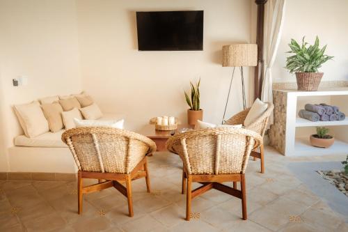 a living room with rattan chairs and a couch at Central Park Luxurious Historical Home With Pool in Granada