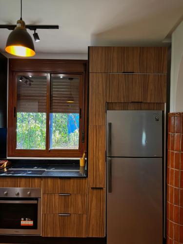 a kitchen with a stainless steel refrigerator and a window at Villa Authentique avec Vue Panoramique à 3 km de Chefchaouen in Chefchaouene