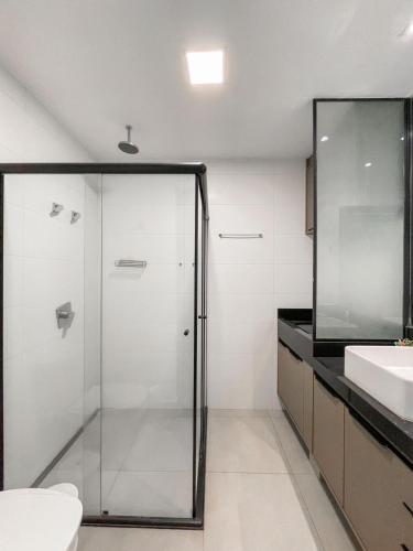 a bathroom with a glass shower and a sink at Alto Luxo e uma Bela Vista no Edifício Vertigo in Campo Grande