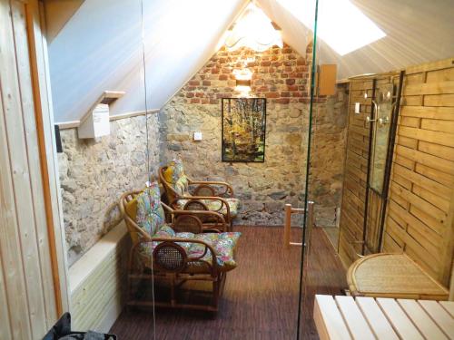 an attic bathroom with chairs and a shower at la linoterie - sauna in Colembert