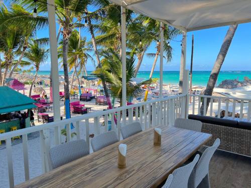 a wooden table on a balcony overlooking the beach at SANDY BAY VILLAS and SUITES playa LOS CORALES in Punta Cana