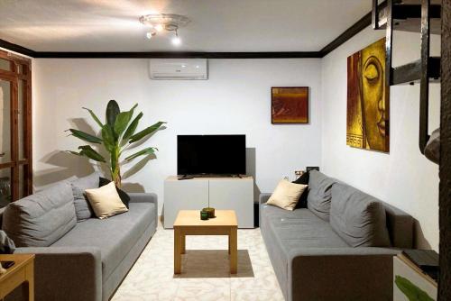a living room with a couch and a tv at Casa Nutt by the Sea in Torrox