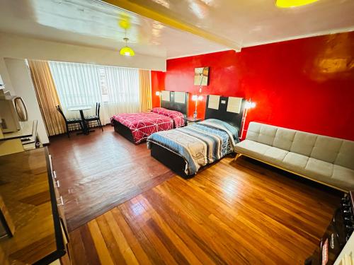 a bedroom with red walls and a bed and a couch at Skyline in La Paz