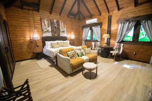 a bedroom with a bed and a couch and windows at Platon Ecolodge in Santa Cruz de Barahona