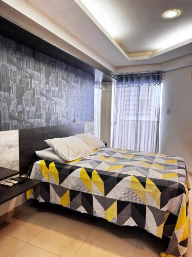 サンタレンにあるApartmento Spazio Moriáのベッドルーム1室(黒と黄色の掛け布団付きのベッド1台付)