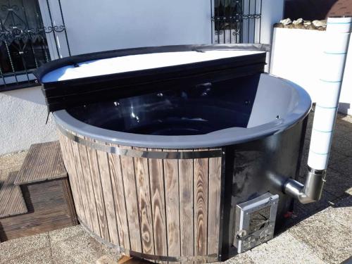 a wooden bath tub sitting on the ground at Lodge in Bohemia with Sauna and Bubble Bath in Kraslice