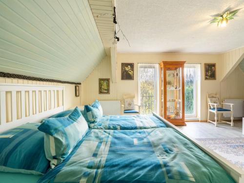 a bedroom with a large bed with blue sheets at Lodge in Bohemia with Sauna and Bubble Bath in Kraslice