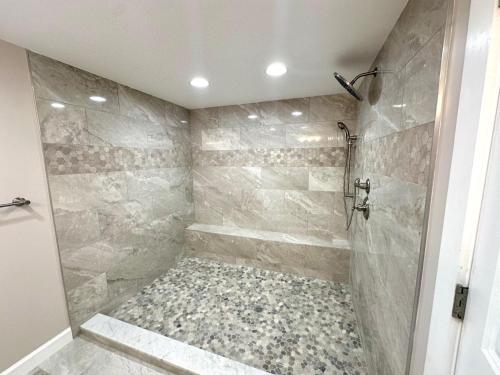 a bathroom with a walk in shower with a stone shower at Paradise Found Cayo Hueso in Key West