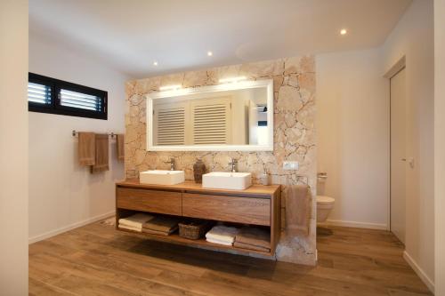 une salle de bain avec deux lavabos et un miroir dans l'établissement Nieuwe luxe villa Blue Bay Resort, à Dorp Sint Michiel