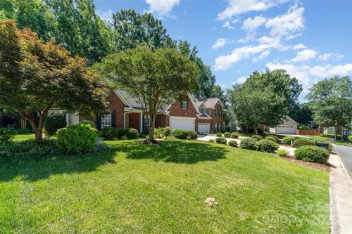 a house with a yard with trees and bushes at Comfortable private room in Charlotte
