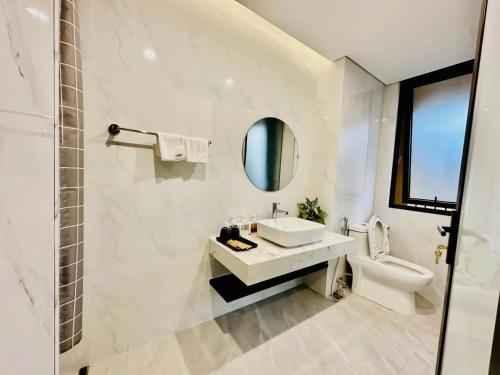 a white bathroom with a sink and a toilet at Khoáng nóng Wyndham Thanh Thủy Onsen in La Phu