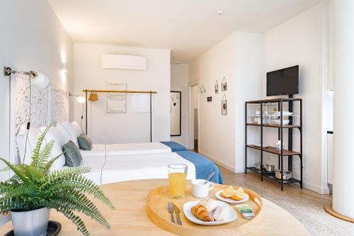 a room with a bed and a table with food on it at Galerias Nightlife Fashion Flats by Feel Porto in Porto