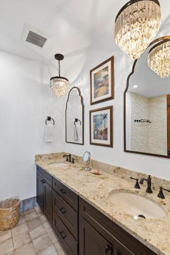 a bathroom with a sink and two chandeliers at Casa Papa Del Mar in Key West