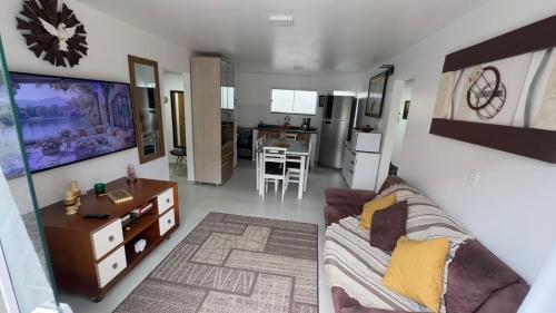 a living room with a couch and a kitchen at Casa espaçosa - Luar da Guarda in Palhoça